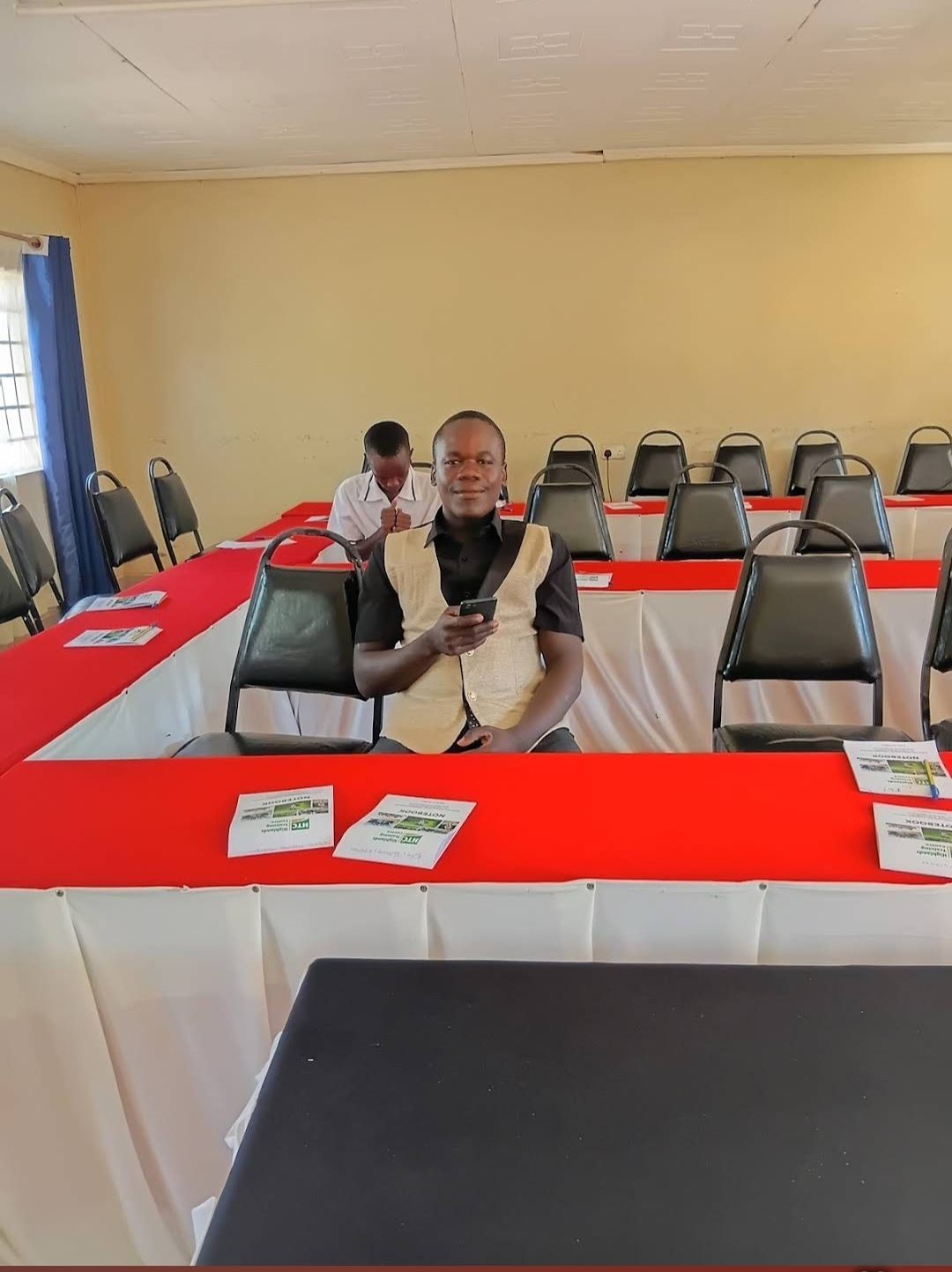 A hall at Highlands Training Centre set boardroom-style with branded notebooks on the tables