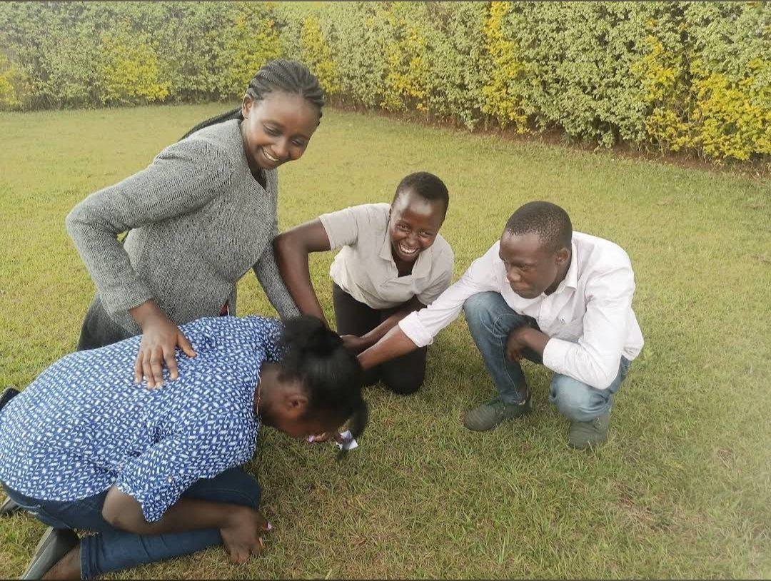 A small group laughing through a lawn game